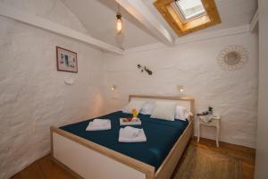 a bedroom with a bed with blue sheets and a window at Kaleta in Vodice