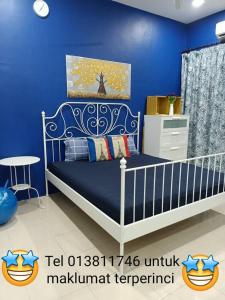 a blue bedroom with a bed and a blue wall at Salju Mewah Homestay in Kampong Sungai Che Lias