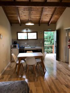 eine Küche und ein Esszimmer mit Tisch und Stühlen in der Unterkunft Departamentos Serendipia Dina Huapi in Dina Huapi
