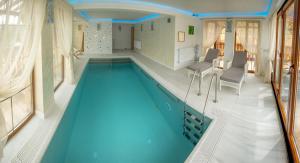 a large swimming pool with blue water in a house at Poiana Brazilor in Borşa