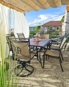 een tafel en stoelen onder een parasol op een patio bij Kaya house in Nerežišće