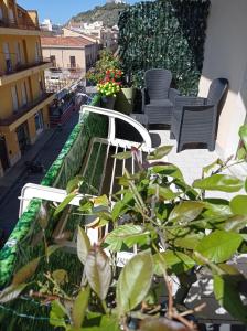 un balcón con un banco y plantas en un edificio en B&B del Centro, en Capo dʼOrlando