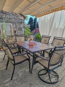 un tavolo e sedie in legno su un patio di Kaya house a Nerežišće