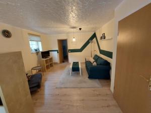 ein Wohnzimmer mit einem blauen Sofa und einer grünen Wand in der Unterkunft Ferienwohnung Waldblick in Brilon