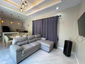 Pool Villa Nita في Ban Na Klang: غرفة معيشة مع أريكة وطاولة