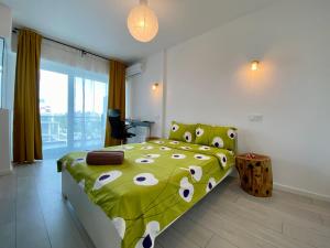 Un dormitorio con una cama verde y blanca y una silla en PLAZA VIEW Studio, en Bucarest
