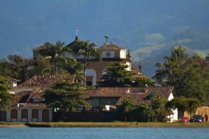 a large building on top of a hill with a church at Casa Park in Paraty