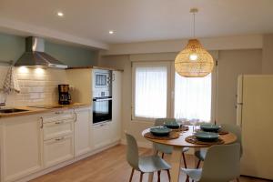 a kitchen with a table and chairs and a dining room at AD Loft apartment, Centro Cambados in Cambados
