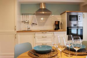 a kitchen with a table with wine glasses on it at AD Loft apartment, Centro Cambados in Cambados +4 photos