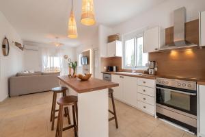 a kitchen with white cabinets and a wooden counter top at Alta Vista 2 Luxury House in Kardamaina