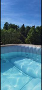 uma grande piscina com água azul em Gîte la source de la bruche em Bourg-Bruche