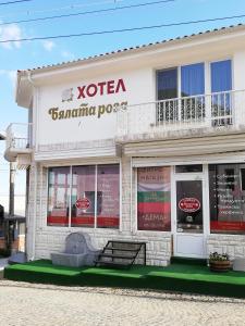 a white building with a sign on the side of it at Хотел Бялата роза in Shipka