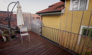 una terraza de madera con una silla blanca y una sombrilla en Budgetapartment Konzil von Swisspartments en Arbon