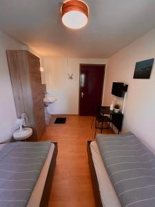 - une chambre avec 2 lits, une table et un bureau dans l'établissement Budgetapartment Konzil von Swisspartments, à Arbon