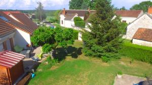 een uitzicht op een tuin met een boom bij laurilia in Saint-Romain-sur-Cher