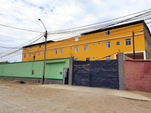 ein gelbes und grünes Gebäude an der Straßenseite in der Unterkunft Casa Talara in Talara