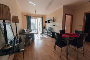 a living room with a table and chairs and a television at Quintas do Mar I in Ribeira Grande