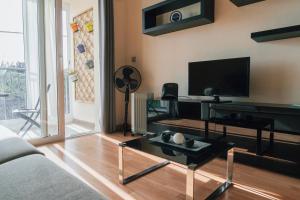 a living room with a couch and a tv at Quintas do Mar I in Ribeira Grande