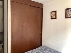 Una puerta de madera en un dormitorio con cama en Fantástica Habitación Privada Colina, en Bogotá
