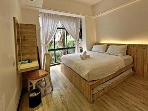 a bedroom with a large bed and a window at Mahkota by The Bliss Malacca in Malacca