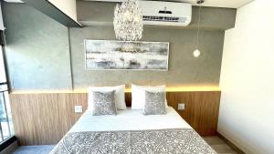 a bedroom with a bed and a chandelier at Haus Stay . Luxo . Vitralli Moema in Sao Paulo