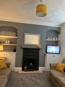 a living room with a fireplace and a flat screen tv at Town House,Walking Distance To Town,Beach,Harbour. in Torquay