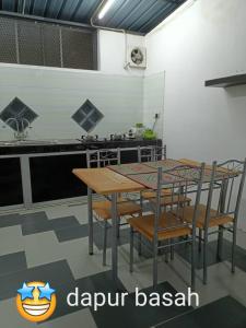 a kitchen with a table and chairs in a kitchen at Salju Mewah Homestay in Kampong Sungai Che Lias