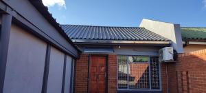 a house with a door and a brick wall at Casa Línda Guest House in Newcastle