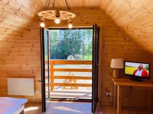 a room with a television in a wooden cabin at KALINOWY SAD DOMKI z JACUZZI i SAUNĄ in Mikołajki