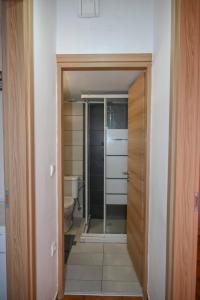 baño con aseo y puerta de cristal en Studio rene 4, en Tinos