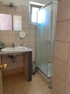 a bathroom with a sink and a shower at Riviera Hotel in Poros