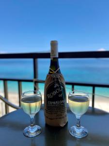 a bottle of champagne and two glasses on a table at Riviera Hotel in Poros