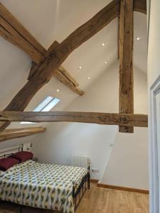 1 dormitorio con 1 cama en una habitación con vigas de madera en Trois Mousquetaires Gîte en Saint-Dizier-Leyrenne