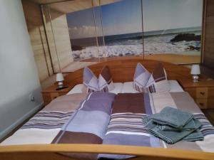 a bed with two pillows and a picture of the beach at Unterkunft Müritz in Waren