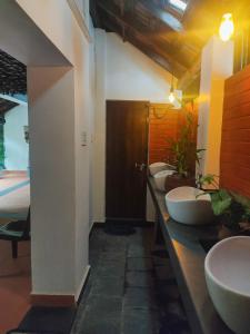 łazienka z czterema umywalkami i rządem toalet w obiekcie Kayyalas Courtyard w mieście Triśur