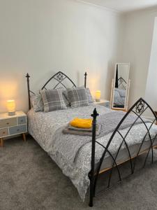 een slaapkamer met een bed, 2 lampen en een spiegel bij Town House,Walking Distance To Town,Beach,Harbour. in Torquay