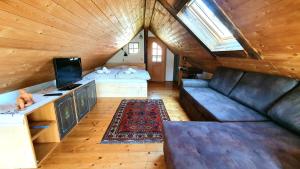 Cette chambre mansardée comprend deux lits et un canapé. dans l'établissement Chalets Toplak, à Sveti Duh na Ostrem Vrhu