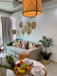 sala de estar con sofá y mesa con fruta. en Ambar 5D - Céntrico apart estilo Boho Chic en Santo Domingo