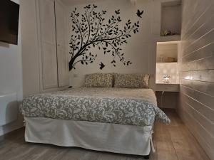 a bedroom with a bed with a tree sticker on the wall at Dimora San Francesco in Bevagna