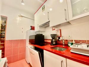 een keuken met een wastafel en een rood aanrecht bij **Fresh and cosy appt with Pool, Fiber, SportTV** in Albufeira