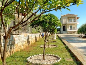 two trees in a garden next to a stone wall at Oasis Villa - Maisonette A in Almirón