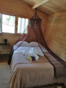 um quarto com uma cama num chalé de madeira em Quinta das Primas em Lomba