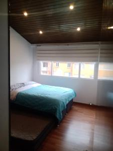 1 dormitorio con 1 cama en una habitación con ventana en HOMY APARTAMENTOS #8 - Apt Grande G12 Agora Corferias embassy UN, en Bogotá
