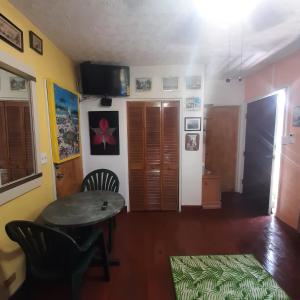a living room with a table and chairs and a television at Garden In Paradise in Nassau