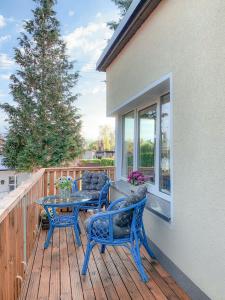 eine Terrasse mit blauen Stühlen und einem Tisch auf einer Terrasse in der Unterkunft Charzykówka Domek na Kaszubach in Charzykowy