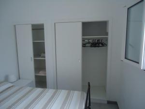 una camera bianca con letto e armadio di Appartamento Leuca a Leuca