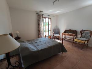 a bedroom with a bed and a table and chairs at La Maison des Romarins Chambres d'hôtes Cosy Climatisées Piscine Cuisine in Aigremont