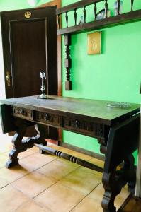 a wooden table in a room with a green wall at Beautiful small House in Algarve Portugal in Mexilhoeira Grande