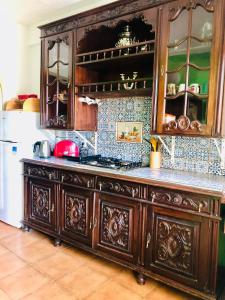 a kitchen with a large wooden cabinet in a kitchen at Beautiful small House in Algarve Portugal in Mexilhoeira Grande