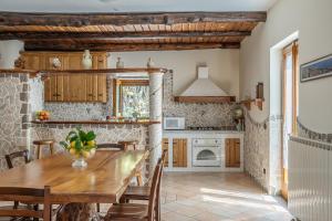 圣安吉洛Villa La Pace的带木桌的厨房和餐厅